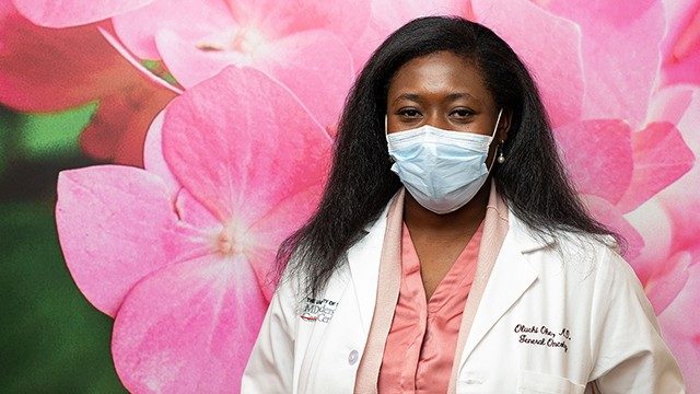 乳房医疗肿瘤学家Oluchi没问题的,医学博士,在一个背景下超大号的粉红色的花的照片