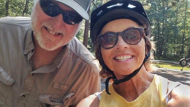 凯西·麦凯和她的丈夫微笑而骑自行车。