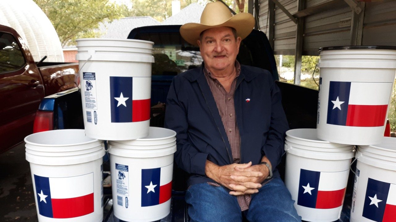 诺兰马克西坐在白色桶与德克萨斯州州旗。