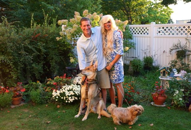 Chris Cook拥抱他的妻子Essie 并站在两条狗旁边